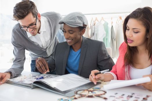 Group of fashion designers discussing designs in a studio