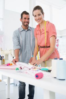 Male and female fashion designers at work in a bright studio