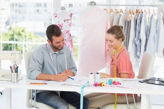 Male and female fashion designers at work in a bright studio