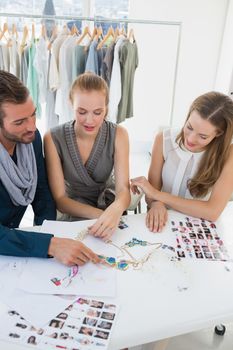 Three fashion designers discussing designs in a studio