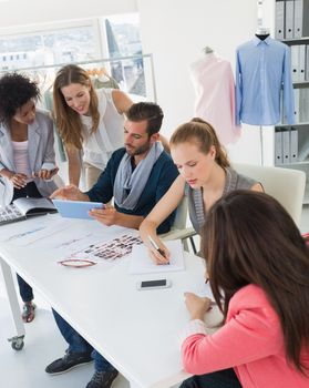 Group of fashion designers discussing designs in a studio