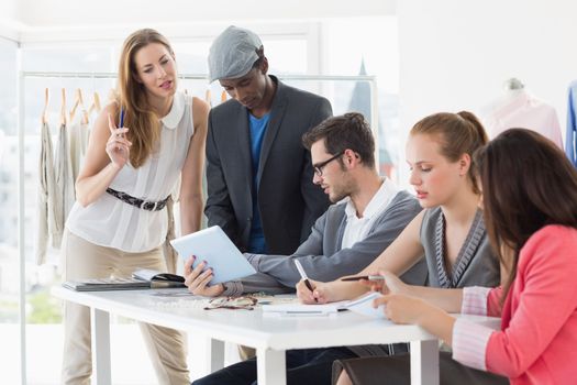 Group of fashion designers discussing designs in a studio