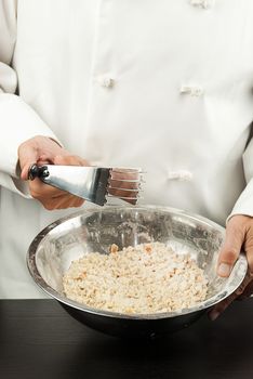 Close-up of a pastry chef preparing a crust, cleaning crumber