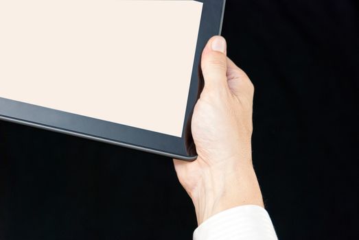 Close-up of a hand holding a tablet, upper left.