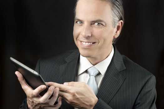 Close-up of a confident businessman using a tablet.