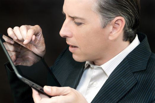 Close-up of a businessman using a tablet, side profile.