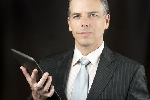 Close-up of a confident businessman holding  tablet.