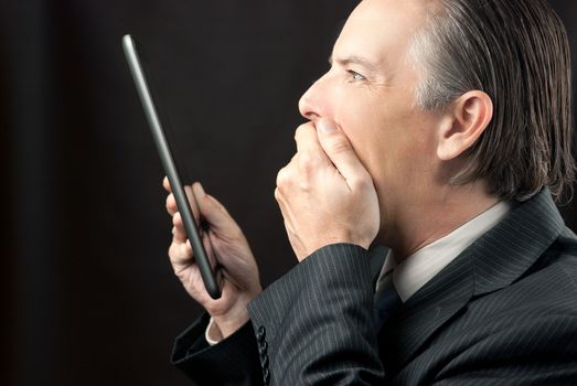 Close-up of a businessman looking at his tablet amazed