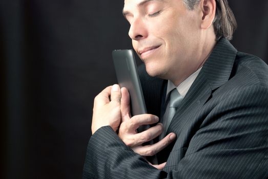 Close-up of a businessman cuddling his tablet