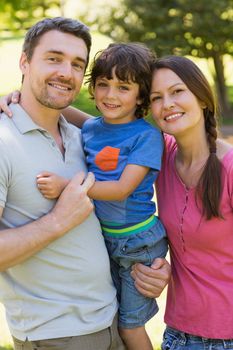 Portrait of a couple with little son standing at the park