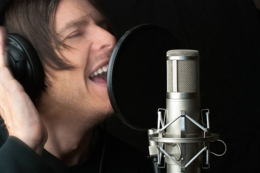 Close-up of a man recording vocals in a sound studio.
