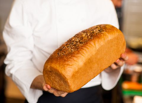 Male chef holding grain bread