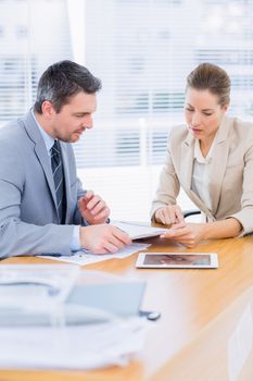 Smartly dressed young man and woman in a business meeting at office desk