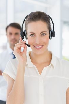 Closeup of a beautiful female executive with headset in a bright office