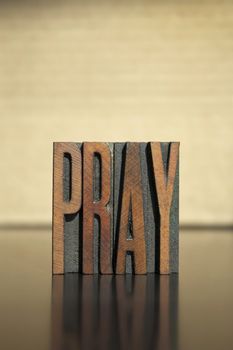 The word PRAY written in vintage letterpress type