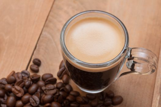 Glass Cup of Espresso Coffee on Wooden Table With Coffee Beans With Copyspace - Shallow Depth of Field