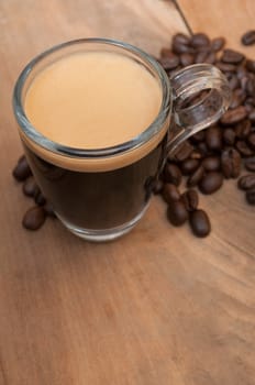 Glass Cup of Espresso Coffee on Wooden Table With Coffee Beans With Copyspace - Shallow Depth of Field