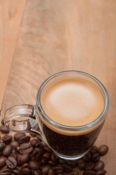 Glass Cup of Espresso Coffee on Wooden Table With Coffee Beans With Copyspace - Shallow Depth of Field