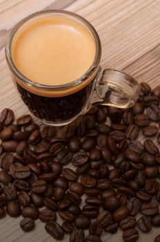 Glass Cup of Espresso Coffee on Wooden Table With Coffee Beans With Copyspace - Shallow Depth of Field