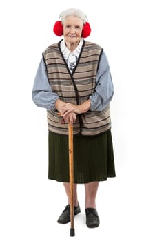 Old woman with a cane wearing red faux fur ear muffs over white