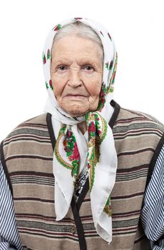 Portrait of a senior woman in headscarf looking at the camera. Over white background.