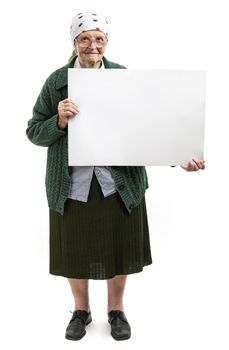 Smiling elderly lady holding blank sheet in hands over white