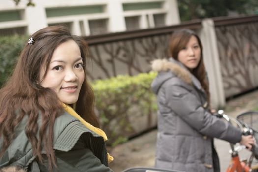 Young Asian woman riding bicycle with friends in city, Taipei, Taiwan.