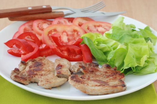 fried pork with salad on the plate