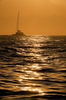 Silhouette of a sailboat on Atlantic ocean at sunrise. South Africa