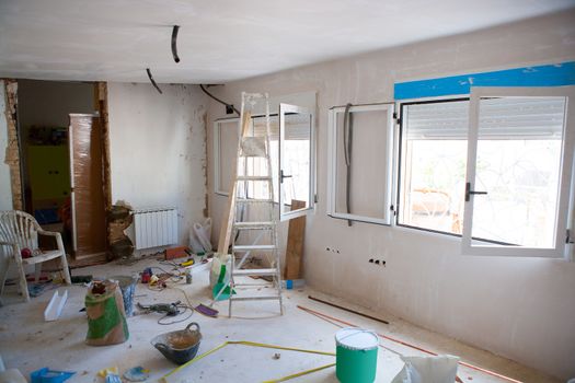 House indoor improvements in a messy room construction with plaste tools and ladder