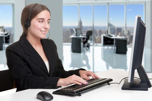 Corporate woman talking over her headset, in an office