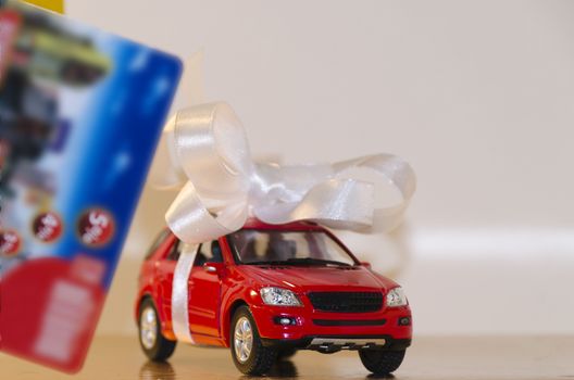 Red machine in a white ribbon and a discount card in the foreground