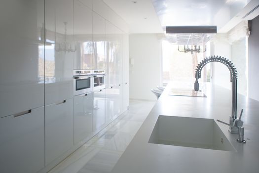 Modern white kitchen perspective with integrated bench sink and spring faucet