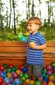 Happy child playing at colorful plastic balls playground high view