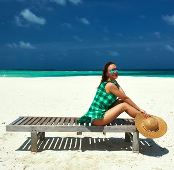 Woman in green dress on a tropical beach at Maldives