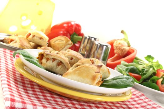 Puff pastry with bell peppers, basil and cheese filling on a light background