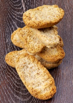 Heap of Crispy Whole Wheat Bread Halves closeup on Hardwood background