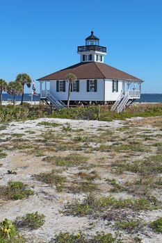 The Port Boca Grande Lighthouse on Gasparilla Island, Florida against a bright blue sky vertical