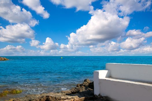 Torrevieja Alicante white bench in the shore rocks of Mediterranean sea