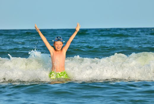 boy at the sea lying in the waves