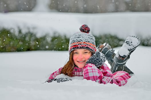 little girl laying on the snow