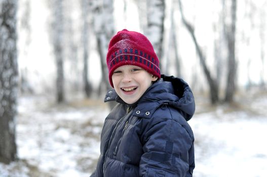 Portrait of the teenage boy in the snow-covered wood