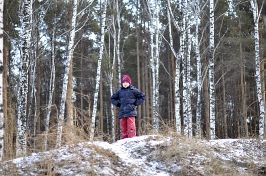 Portrait of the teenage boy in the snow-covered wood