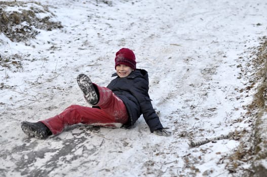 the teenage boy rides from a hill in the snow-covered wood