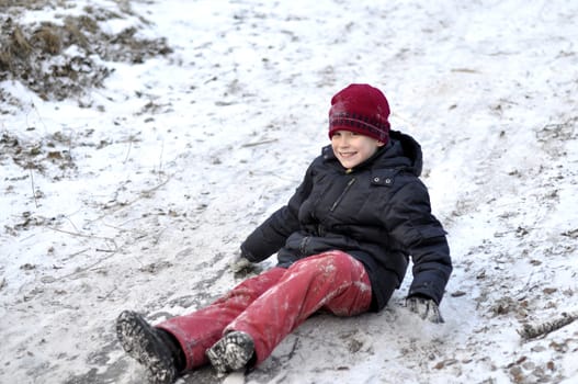 the teenage boy rides from a hill in the snow-covered wood