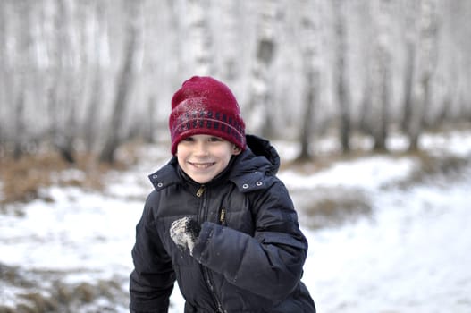 Portrait of the teenage boy in the snow-covered wood