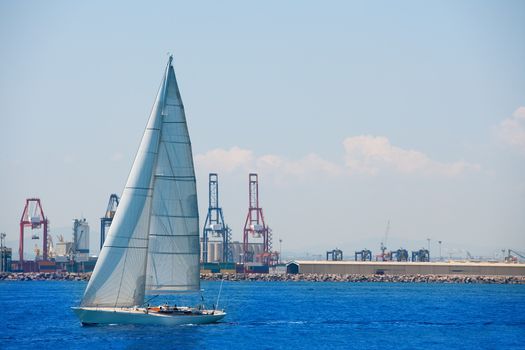 Valencia city port with sailboat and cranes in background at spain