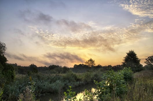 Sunrise over the river with beautiful Golden clouds in summer