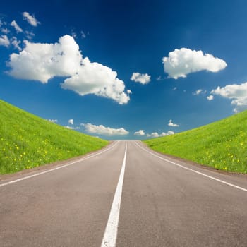 Road beetween summer hills and blue sky