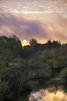 Sunrise over the river with beautiful Golden clouds in summer